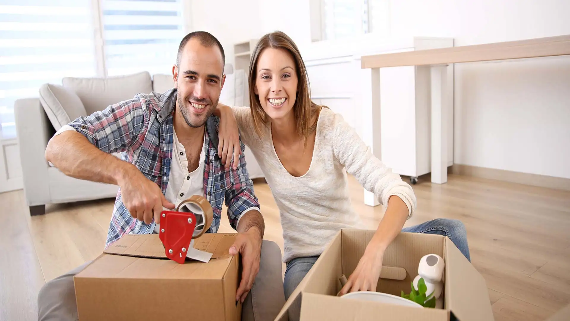 a couple smiling while packing boxes